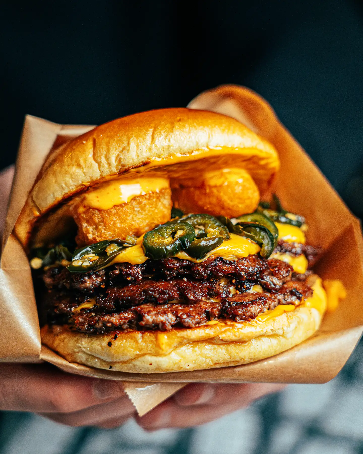 Burgare med jalapeños och chili cheese i handen